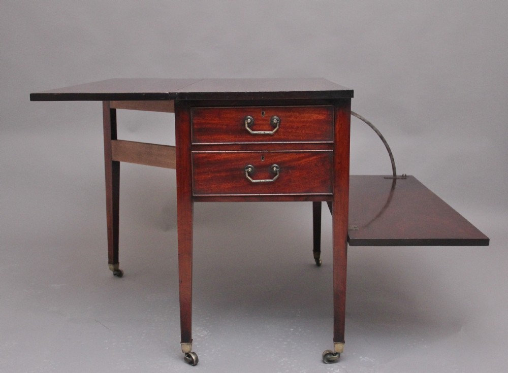 An 18th-century mahogany drop-leaf side table featuring two end drawers with brass bail handles and square tapered legs ending in brass castors. View IV