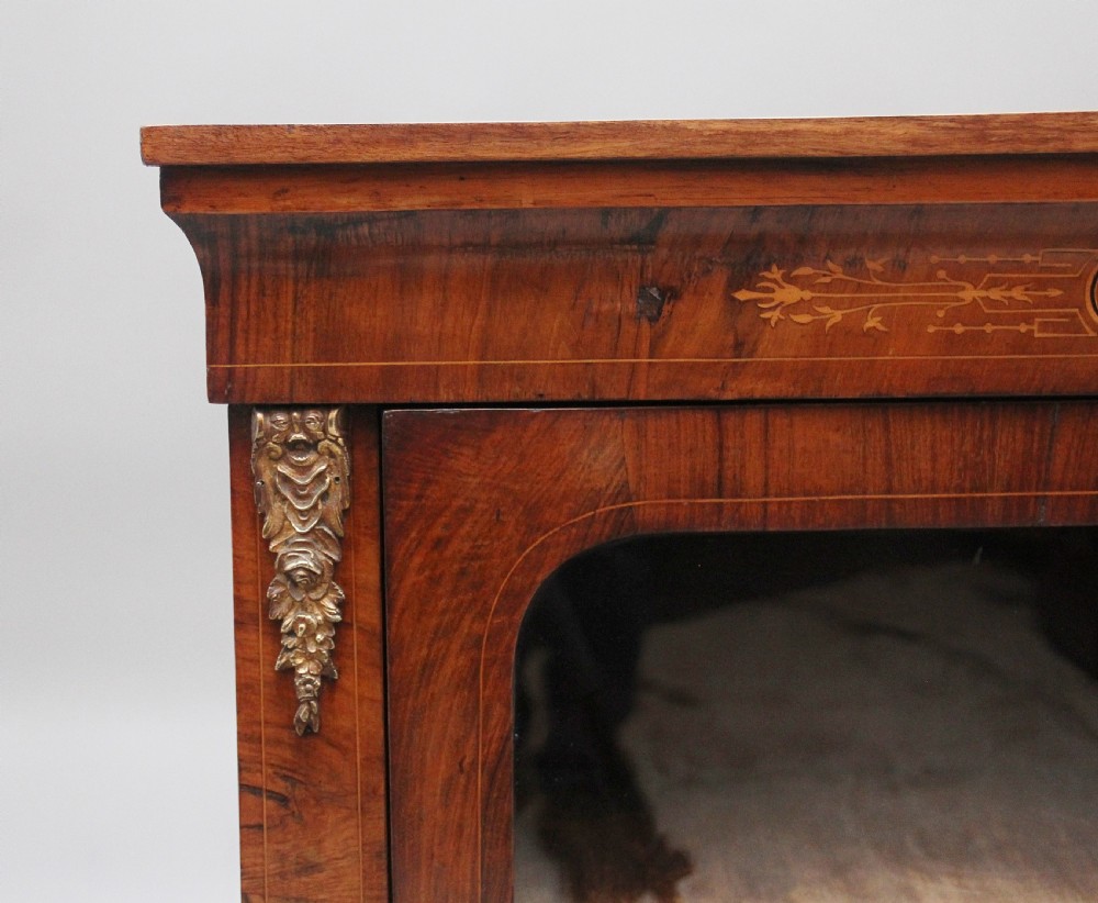 A 19th-century walnut pier cabinet featuring floral marquetry inlays, decorative brass mounts, and a single glazed door revealing fitted shelves. View IX
