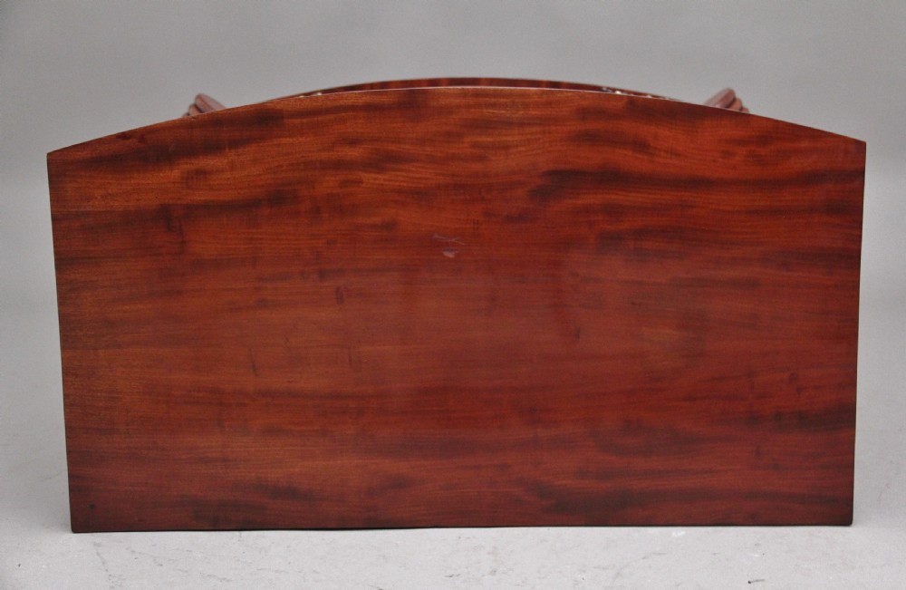 An early nineteenth-century flame mahogany bowfront chest featuring four graduated drawers with inlaid banding and brass handles. View VIII