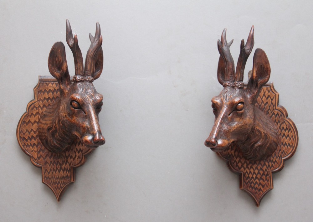 A pair of decorative 19th Century carved walnut black forest deer heads