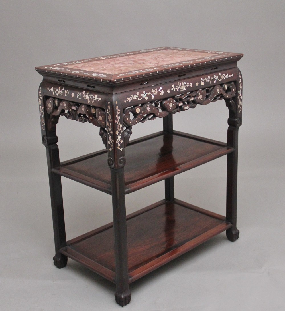 A dark hardwood Chinese three-tier occasional table featuring intricate mother-of-pearl floral inlay and a pink mottled marble top inset.