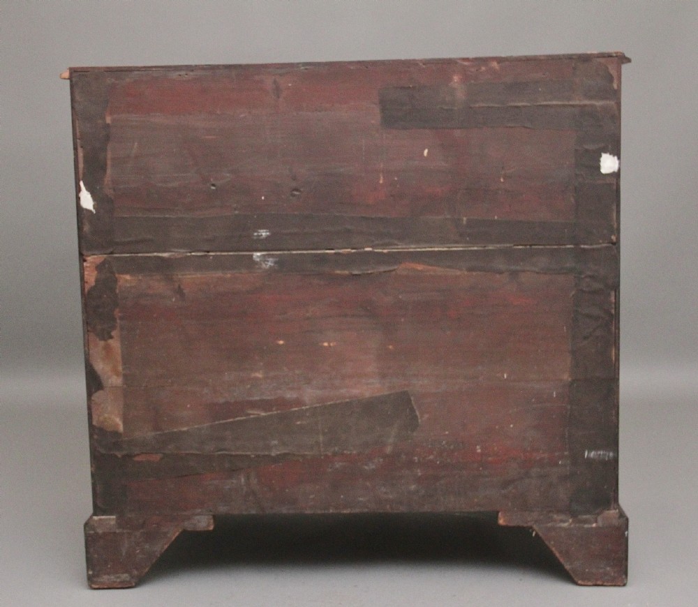 An early 19th-century flat-fronted mahogany chest of drawers featuring two short over three long drawers with brass handles and bracket feet. View VII