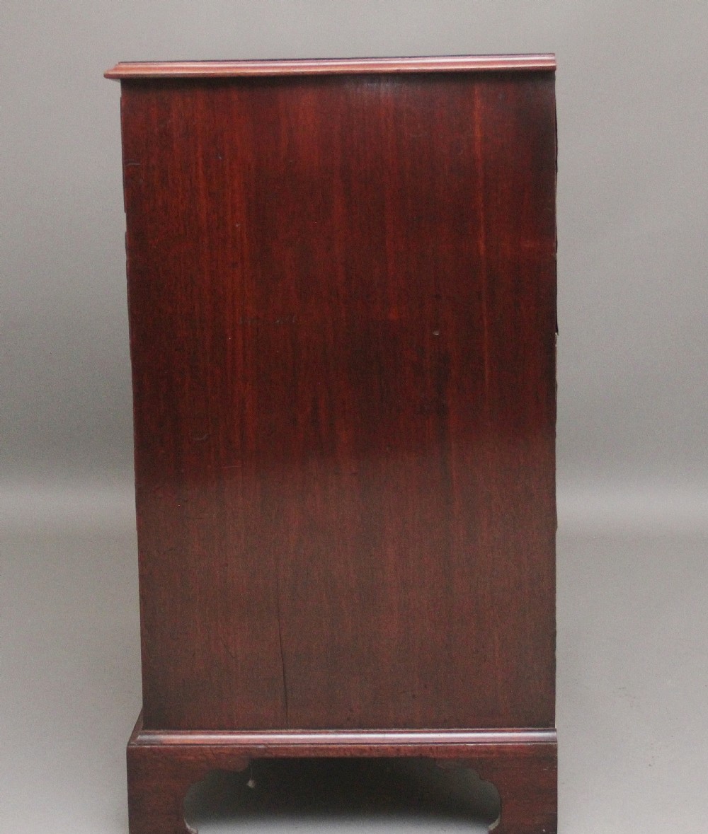 An early 19th-century flat-fronted mahogany chest of drawers featuring two short over three long drawers with brass handles and bracket feet. View VIII