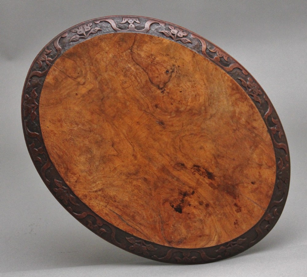 A 19th-century circular walnut occasional table featuring a carved rim, turned central column, and three carved cabriole tripod legs. View III