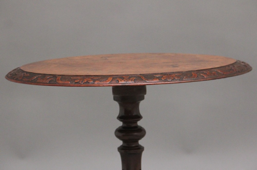 A 19th-century circular walnut occasional table featuring a carved rim, turned central column, and three carved cabriole tripod legs. View VI