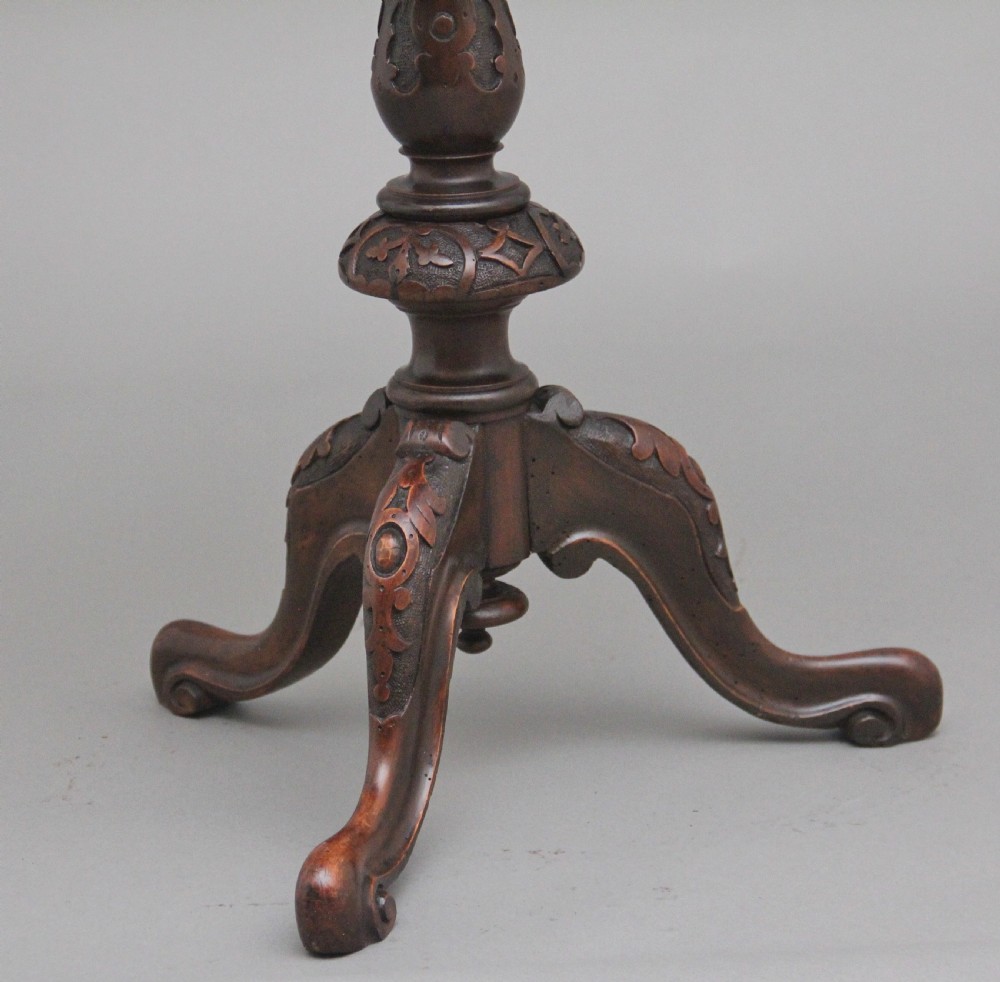 A 19th-century circular walnut occasional table featuring a carved rim, turned central column, and three carved cabriole tripod legs. View VIII