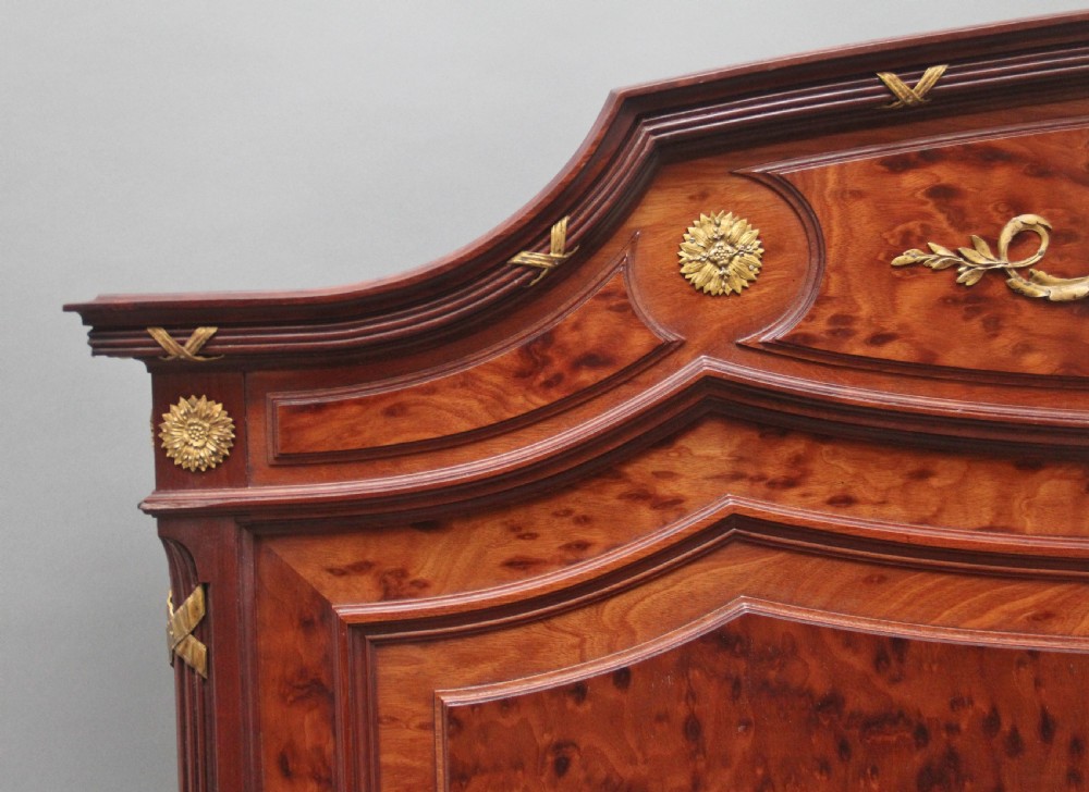 A 19th-century French Neoclassical bed frame crafted from dark mottled mahogany featuring decorative brass scroll mounts and a carved central medallion. View IV