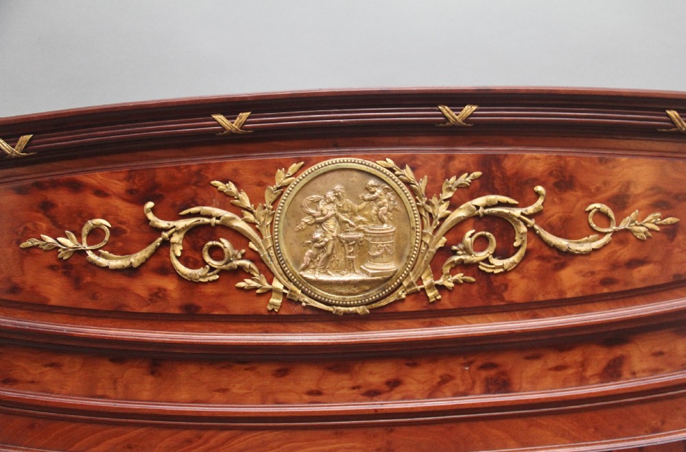 A 19th-century French Neoclassical bed frame crafted from dark mottled mahogany featuring decorative brass scroll mounts and a carved central medallion. View V