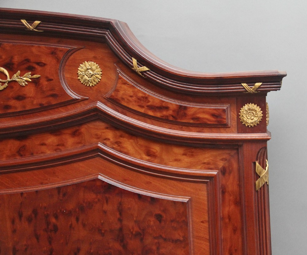 A 19th-century French Neoclassical bed frame crafted from dark mottled mahogany featuring decorative brass scroll mounts and a carved central medallion. View VII