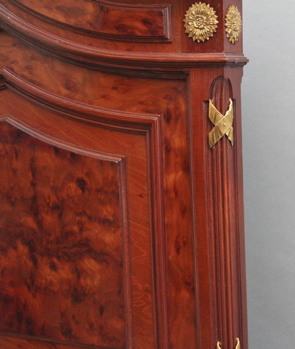 A 19th-century French Neoclassical bed frame crafted from dark mottled mahogany featuring decorative brass scroll mounts and a carved central medallion. View VIII