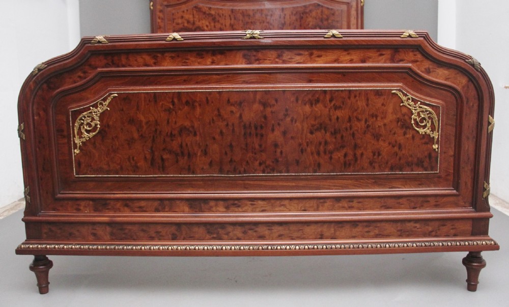 A 19th-century French Neoclassical bed frame crafted from dark mottled mahogany featuring decorative brass scroll mounts and a carved central medallion. View IX