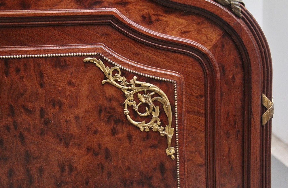 A 19th-century French Neoclassical bed frame crafted from dark mottled mahogany featuring decorative brass scroll mounts and a carved central medallion. View XII
