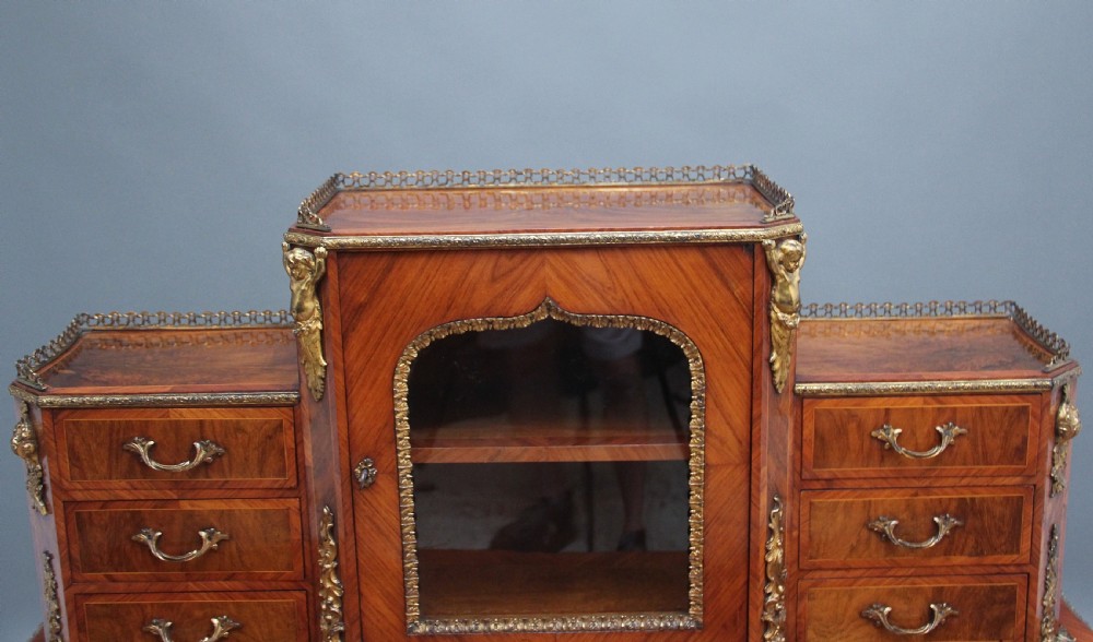 A 19th-century walnut writing desk featuring ornamental gilt-bronze mounts, cabriole legs, and a raised central glazed cabinet flanked by drawers. View XVI