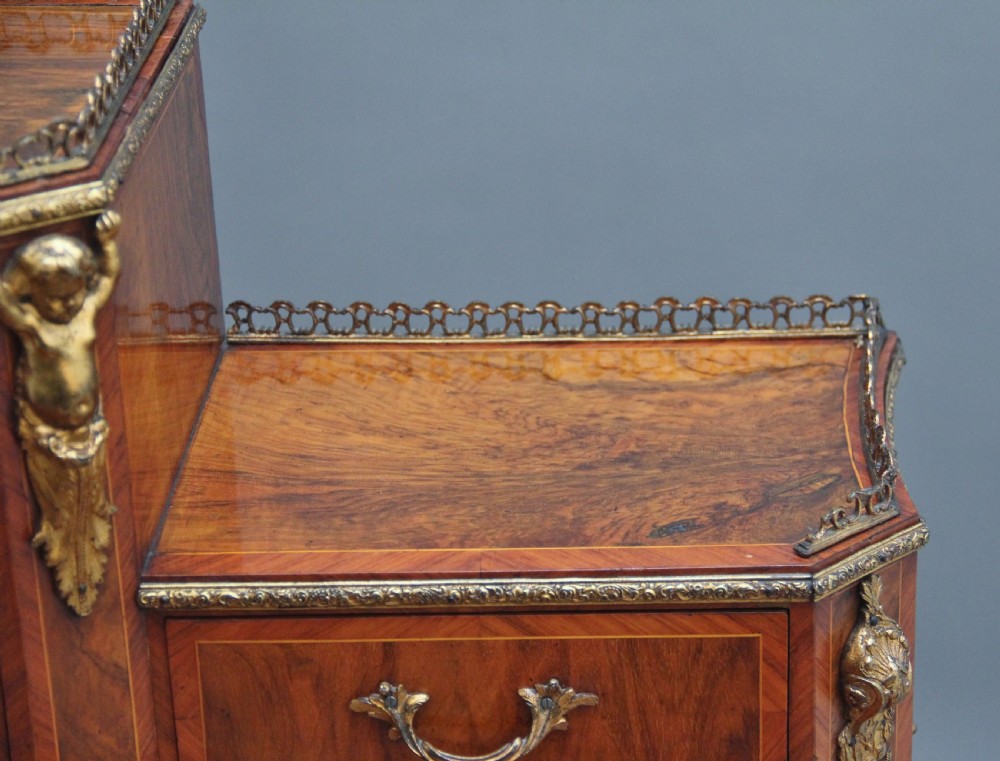 A 19th-century walnut writing desk featuring ornamental gilt-bronze mounts, cabriole legs, and a raised central glazed cabinet flanked by drawers. View XIX