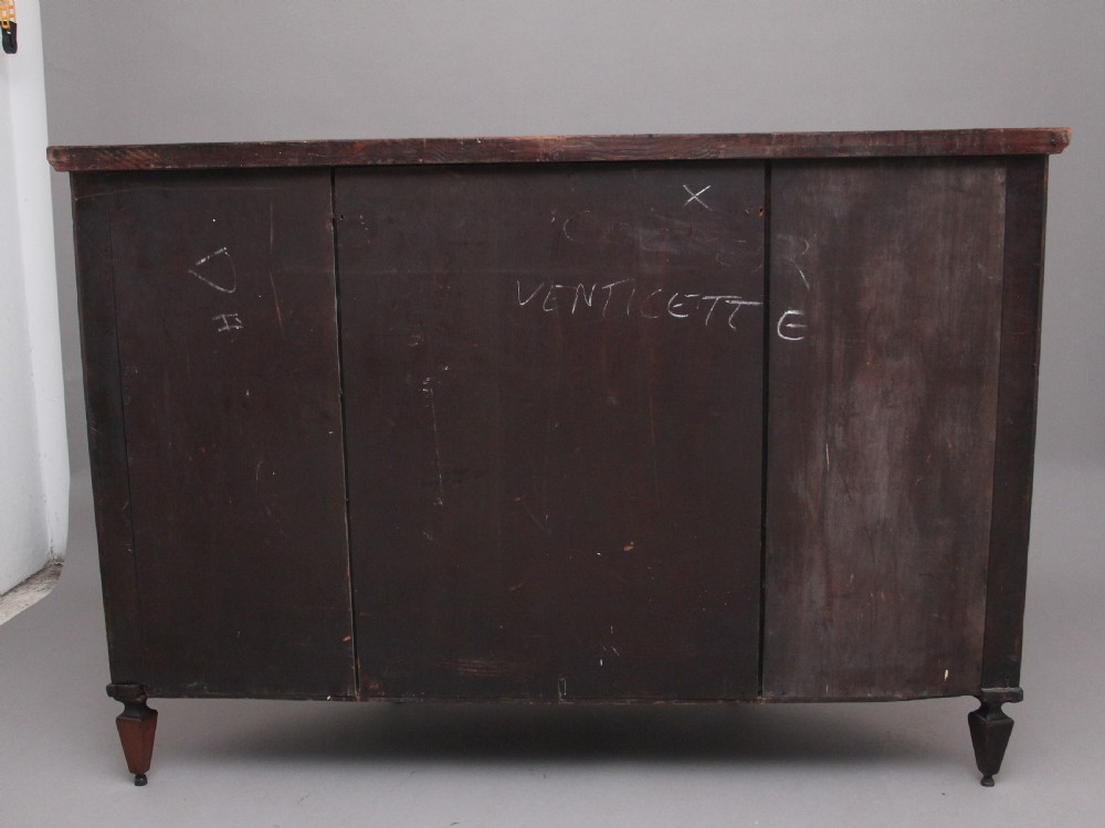 A 19th-century curved mahogany cabinet featuring intricate satinwood marquetry panels depicting classical figures, swags, and scrollwork. View VII
