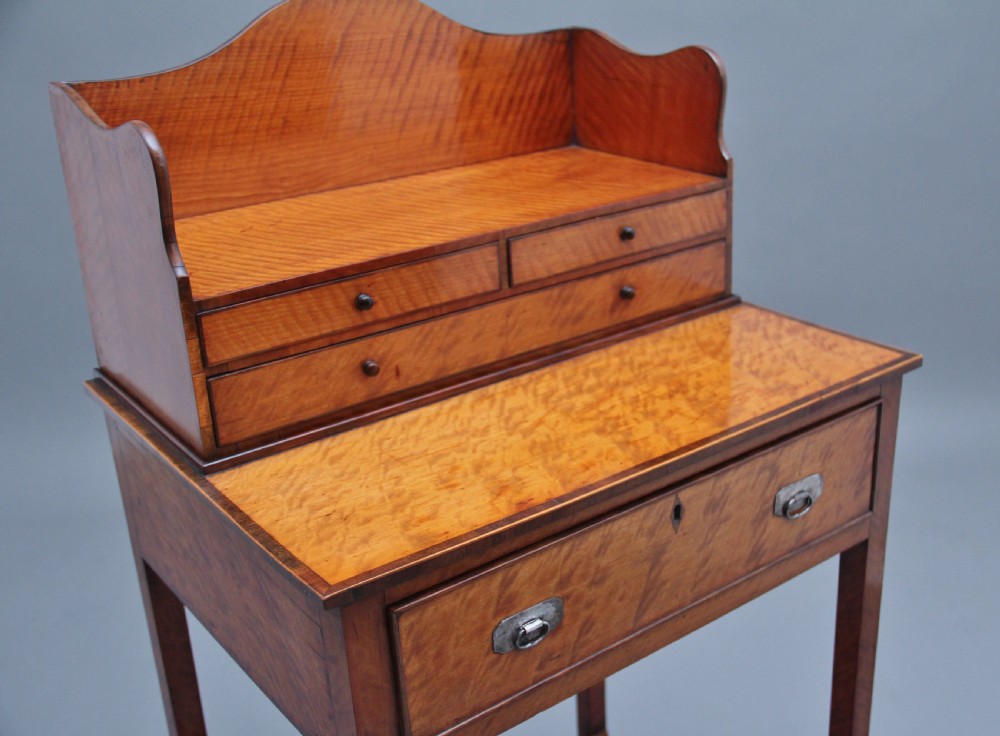 A 19th-century satinwood ladies writing table featuring a raised gallery back with small drawers, a single frieze drawer, square tapered legs, and a curved lower shelf. View VII