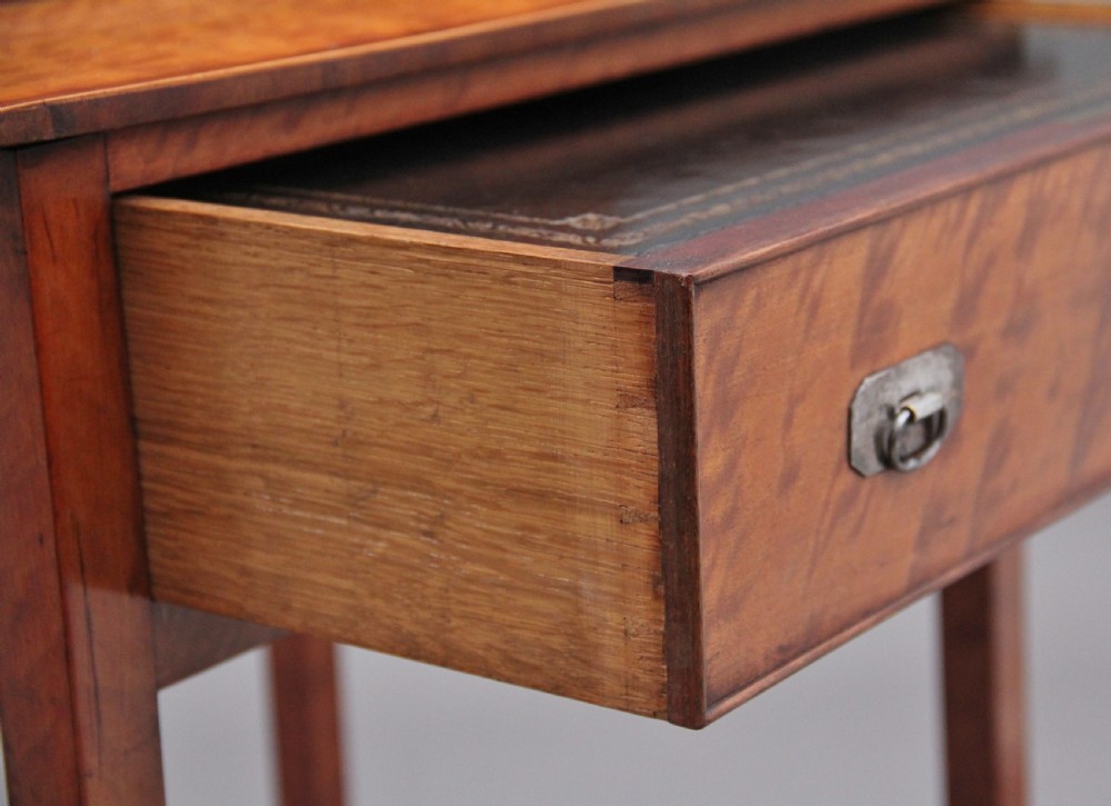 A 19th-century satinwood ladies writing table featuring a raised gallery back with small drawers, a single frieze drawer, square tapered legs, and a curved lower shelf. View XII