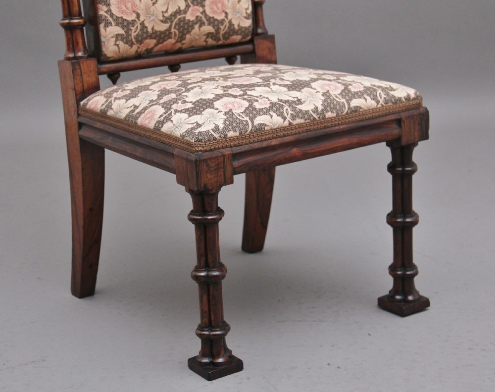 An early 19th-century Gothic Revival rosewood side chair featuring a tall upholstered back, floral pattern fabric, and clustered column turned legs. View VII