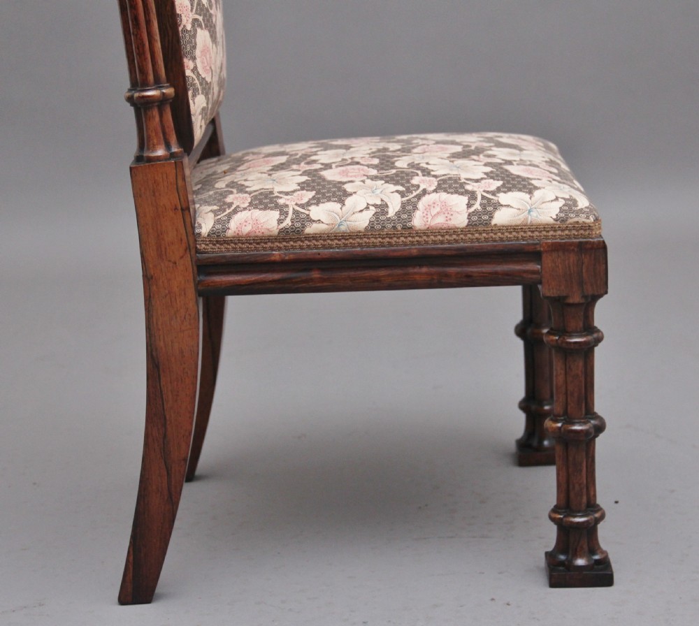 An early 19th-century Gothic Revival rosewood side chair featuring a tall upholstered back, floral pattern fabric, and clustered column turned legs. View IX