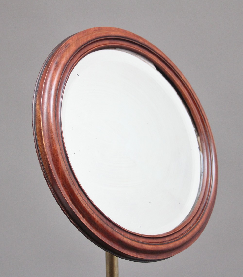 A 19th-century mahogany telescopic shaving mirror featuring a circular adjustable mirror mounted on a brass rod above a small round tray surface and carved tripod legs. View III