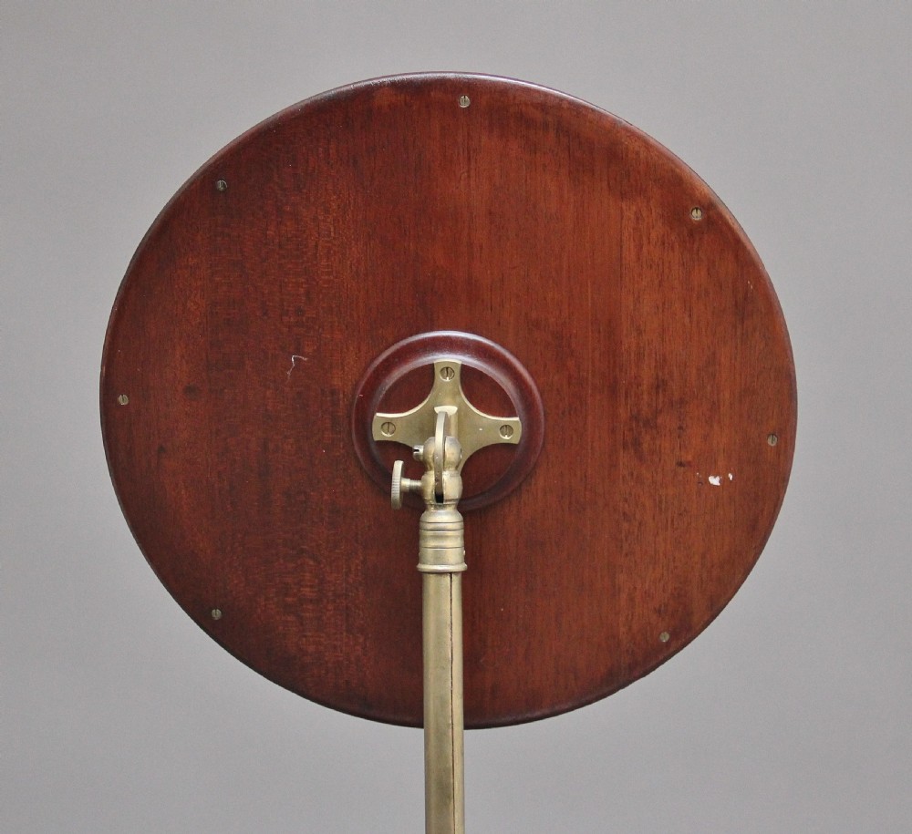 A 19th-century mahogany telescopic shaving mirror featuring a circular adjustable mirror mounted on a brass rod above a small round tray surface and carved tripod legs. View IV