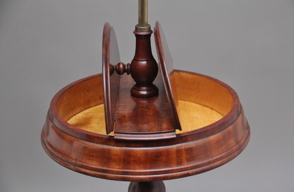 A 19th-century mahogany telescopic shaving mirror featuring a circular adjustable mirror mounted on a brass rod above a small round tray surface and carved tripod legs. View VI
