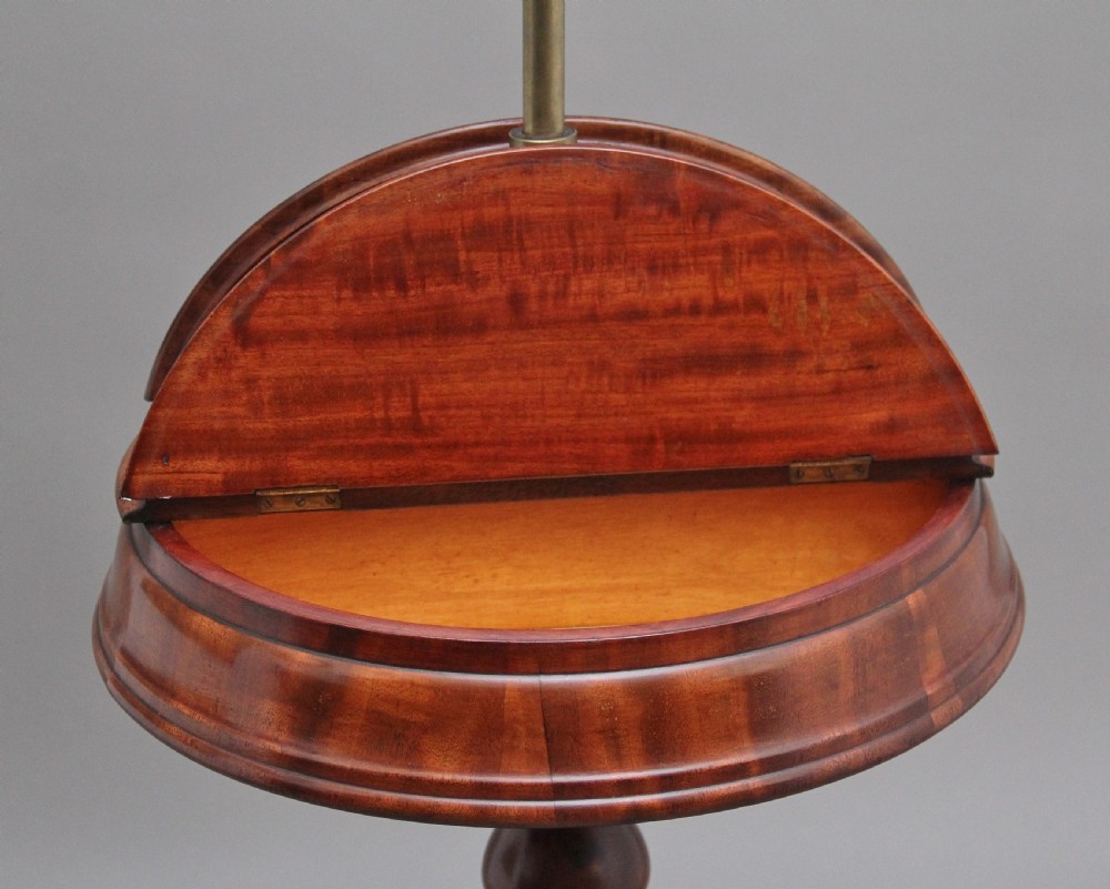 A 19th-century mahogany telescopic shaving mirror featuring a circular adjustable mirror mounted on a brass rod above a small round tray surface and carved tripod legs. View VII