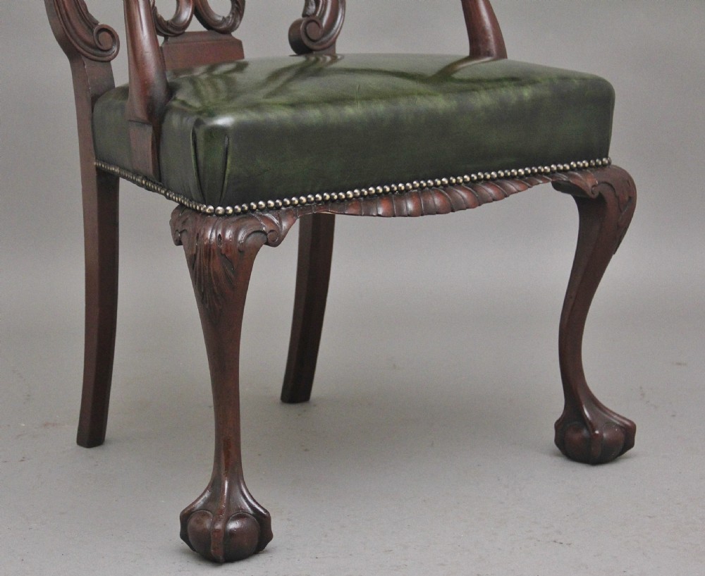 An early 20th-century Chippendale style mahogany armchair featuring a detailed pierced back splat, green leather upholstered seat with brass studding, curved armrests, and cabriole front legs terminating in claw and ball feet. View II