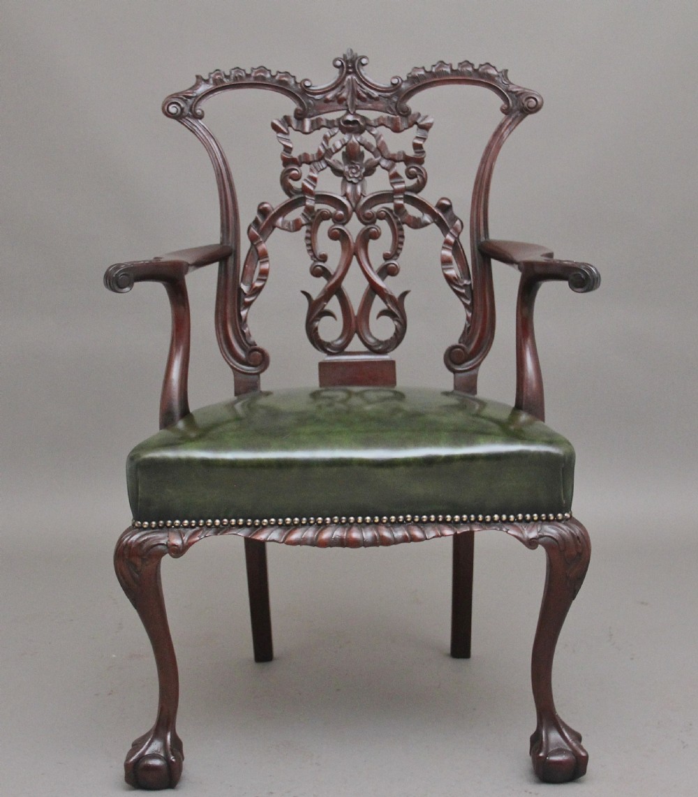 An early 20th-century Chippendale style mahogany armchair featuring a detailed pierced back splat, green leather upholstered seat with brass studding, curved armrests, and cabriole front legs terminating in claw and ball feet. View III