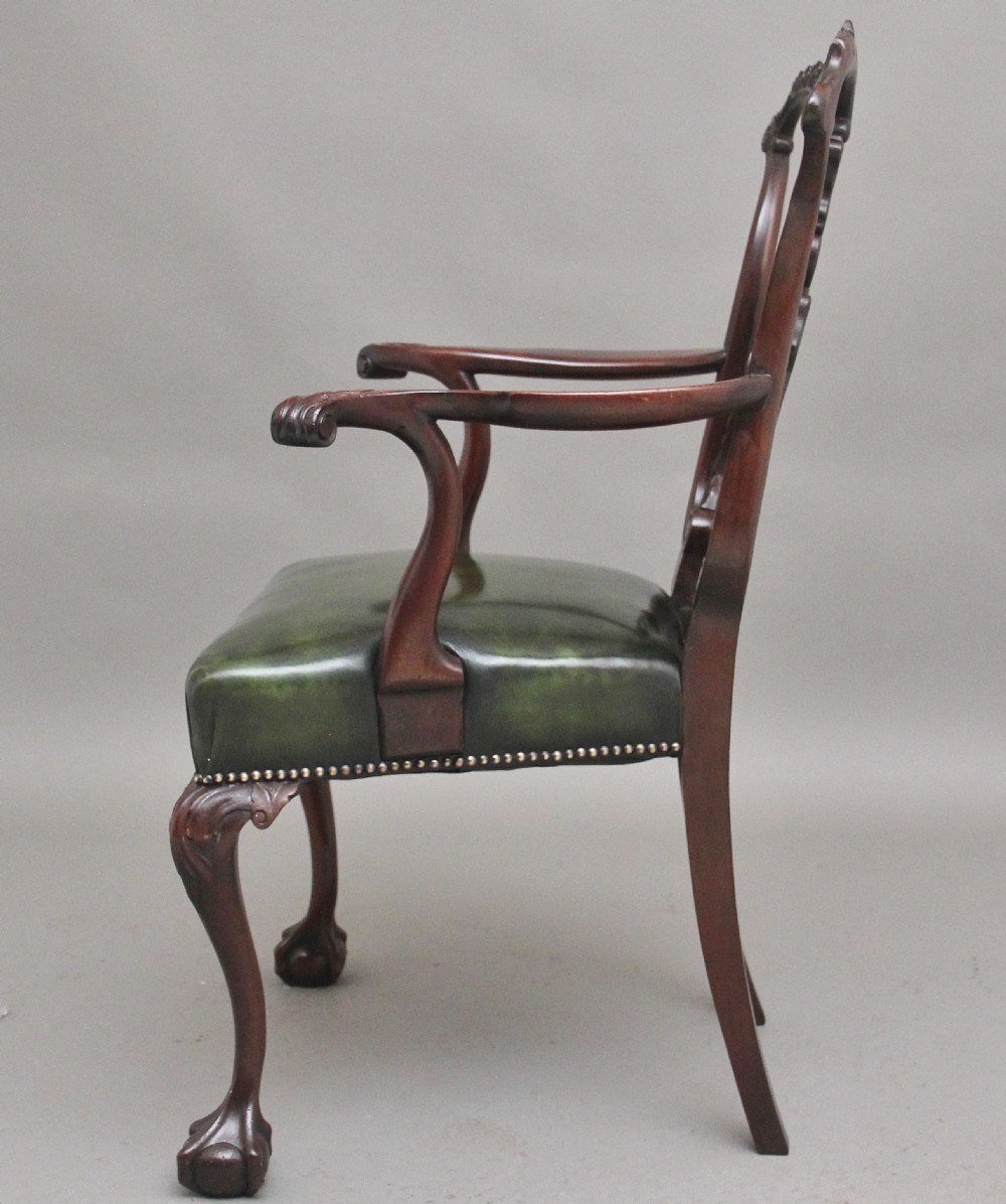 An early 20th-century Chippendale style mahogany armchair featuring a detailed pierced back splat, green leather upholstered seat with brass studding, curved armrests, and cabriole front legs terminating in claw and ball feet. View VI
