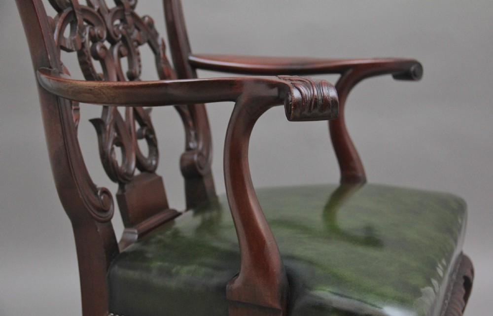 An early 20th-century Chippendale style mahogany armchair featuring a detailed pierced back splat, green leather upholstered seat with brass studding, curved armrests, and cabriole front legs terminating in claw and ball feet. View VIII