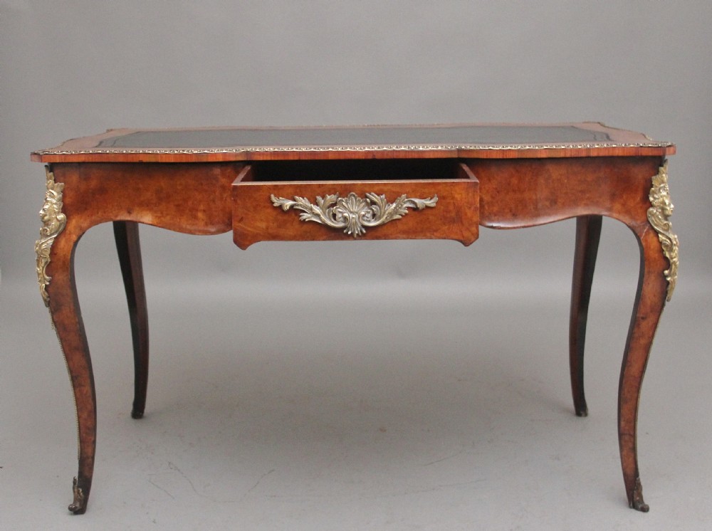 A 19th-century burr walnut bureau plat writing table with decorative gilt-bronze mounts, cabriole legs, and a dark leather inset top. View II