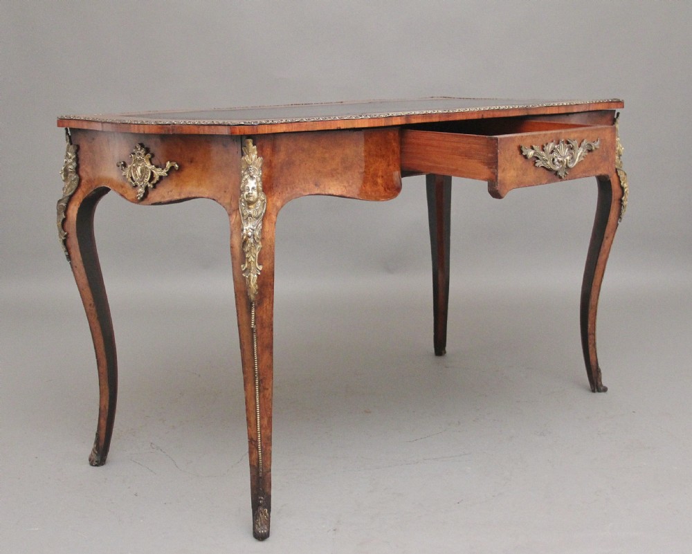 A 19th-century burr walnut bureau plat writing table with decorative gilt-bronze mounts, cabriole legs, and a dark leather inset top. View III