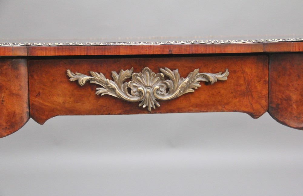A 19th-century burr walnut bureau plat writing table with decorative gilt-bronze mounts, cabriole legs, and a dark leather inset top. View XI