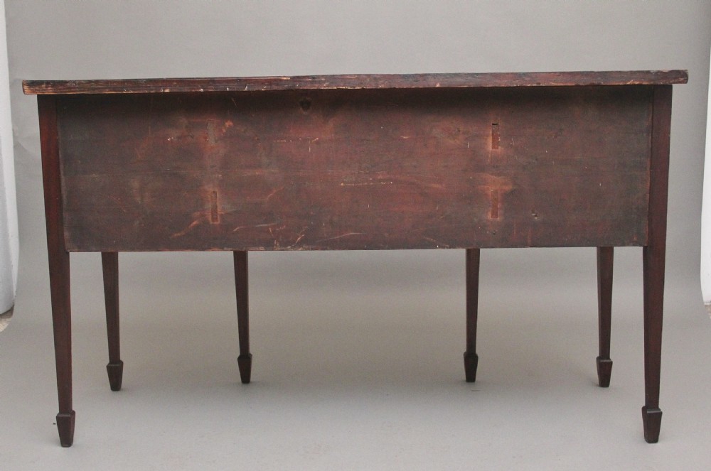 An early nineteenth-century mahogany bowfront sideboard with line inlay, central arch detail, brass lion mask ring handles, and tapered square legs. View VIII