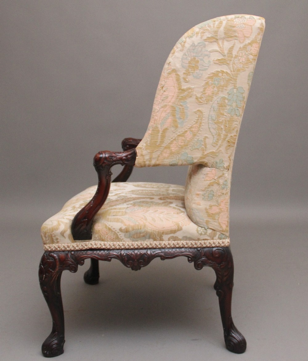 A 19th-century mahogany wingback armchair featuring carved cabriole legs, claw-and-ball feet, and patterned cream damask upholstery. View IV