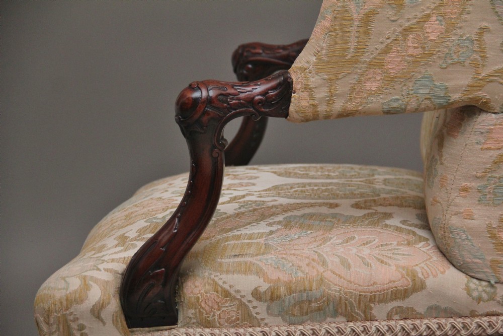 A 19th-century mahogany wingback armchair featuring carved cabriole legs, claw-and-ball feet, and patterned cream damask upholstery. View XI