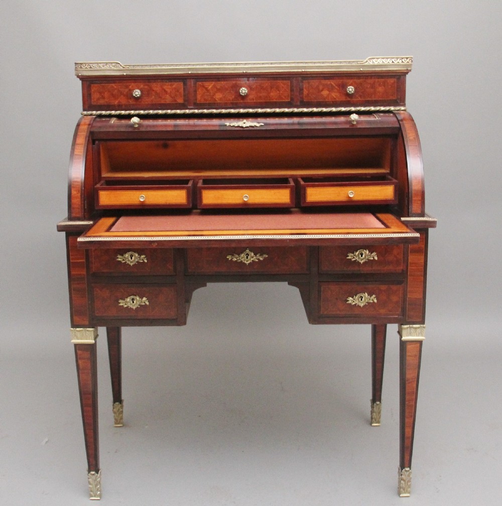 A 19th-century French kingwood cylinder desk featuring parquetry veneering, gilt-brass mounts, tapered square legs, and a curved roll-top section over multiple small drawers. View III