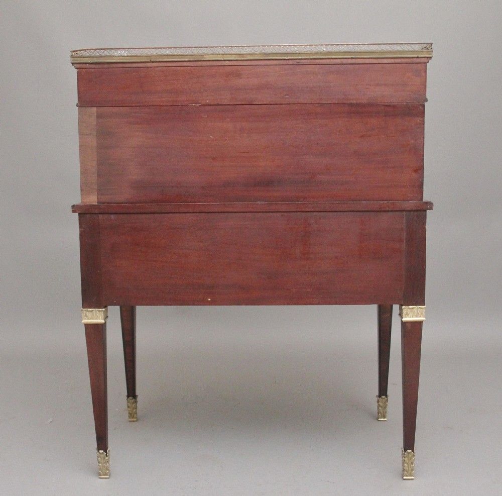 A 19th-century French kingwood cylinder desk featuring parquetry veneering, gilt-brass mounts, tapered square legs, and a curved roll-top section over multiple small drawers. View XIX