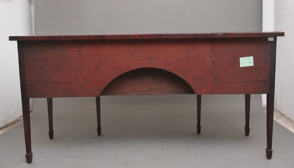 A 19th-century mahogany bowfront sideboard featuring marquetry inlay borders, brass oval handles, central arched drawer, and tapered legs. View VI