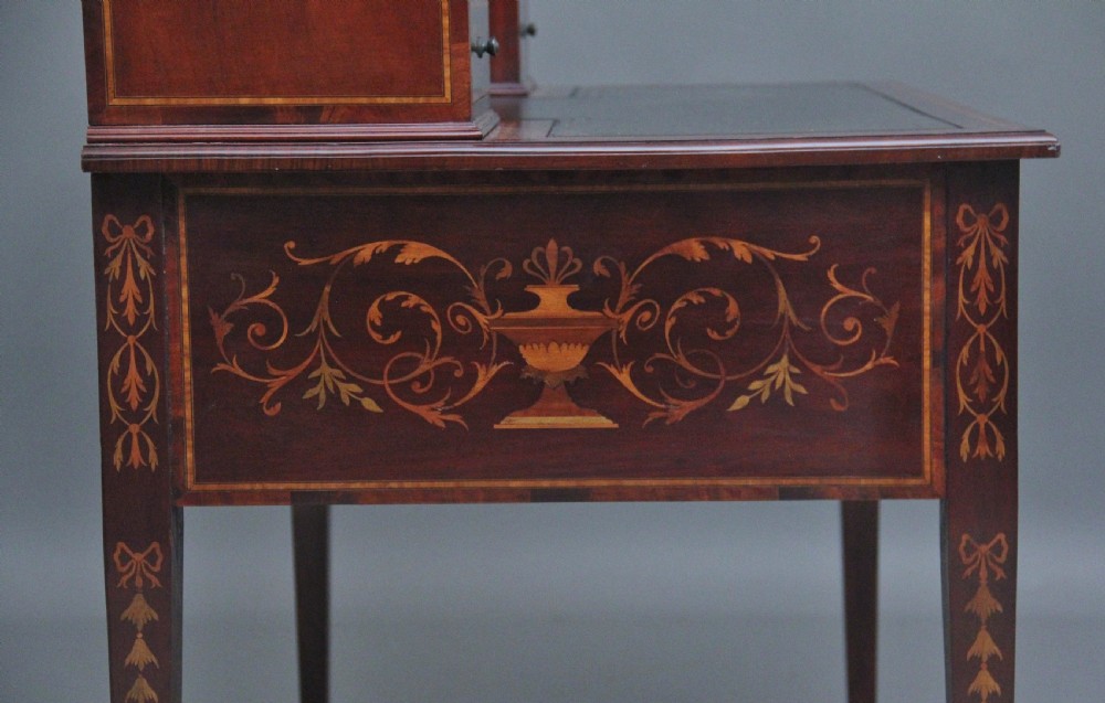 A 19th-century mahogany writing desk featuring intricate floral marquetry inlays, a raised gallery with drawers, square tapered legs, and brass castors. View V