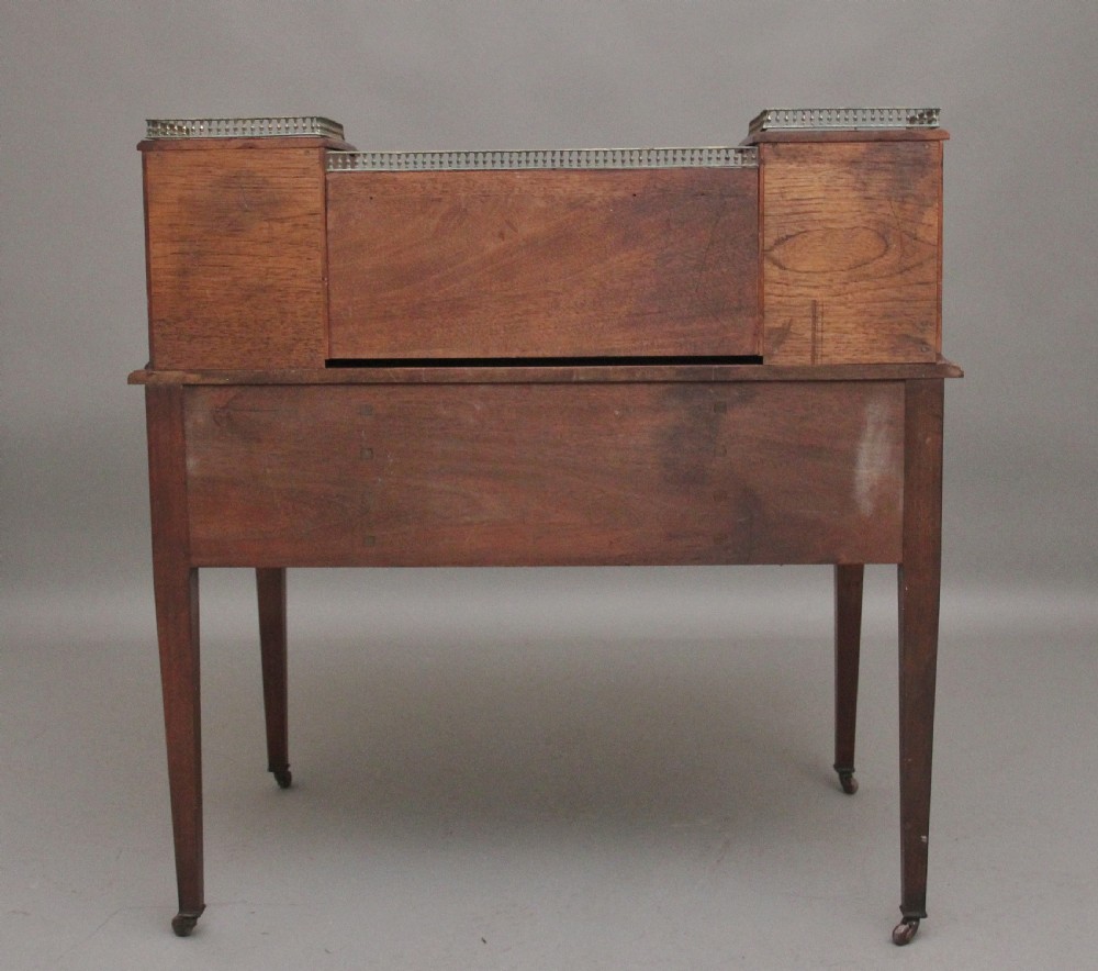 A 19th-century mahogany writing desk featuring intricate floral marquetry inlays, a raised gallery with drawers, square tapered legs, and brass castors. View VI