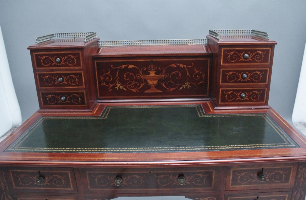A 19th-century mahogany writing desk featuring intricate floral marquetry inlays, a raised gallery with drawers, square tapered legs, and brass castors. View VIII