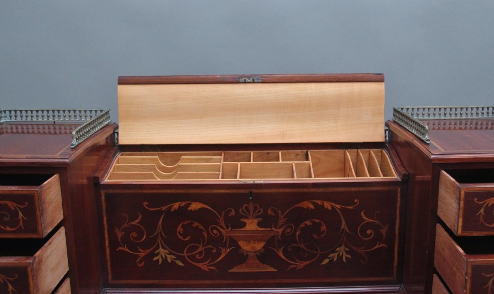 A 19th-century mahogany writing desk featuring intricate floral marquetry inlays, a raised gallery with drawers, square tapered legs, and brass castors. View XI