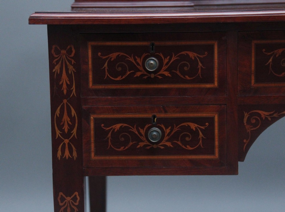 A 19th-century mahogany writing desk featuring intricate floral marquetry inlays, a raised gallery with drawers, square tapered legs, and brass castors. View XII