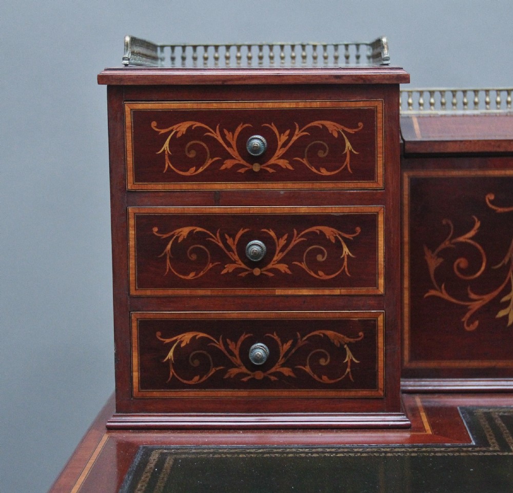 A 19th-century mahogany writing desk featuring intricate floral marquetry inlays, a raised gallery with drawers, square tapered legs, and brass castors. View XIII