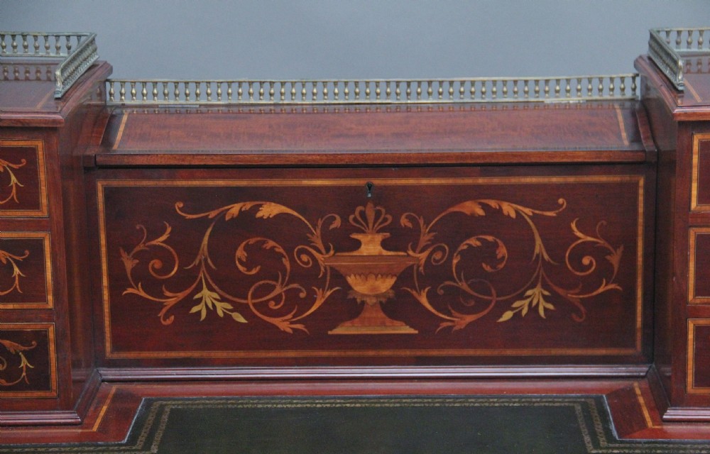 A 19th-century mahogany writing desk featuring intricate floral marquetry inlays, a raised gallery with drawers, square tapered legs, and brass castors. View XIV