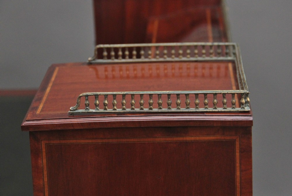 A 19th-century mahogany writing desk featuring intricate floral marquetry inlays, a raised gallery with drawers, square tapered legs, and brass castors. View XV