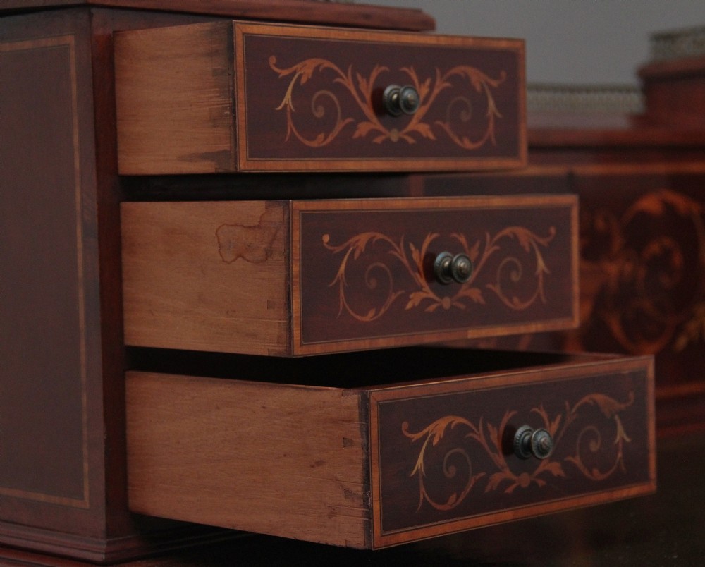 A 19th-century mahogany writing desk featuring intricate floral marquetry inlays, a raised gallery with drawers, square tapered legs, and brass castors. View XVII