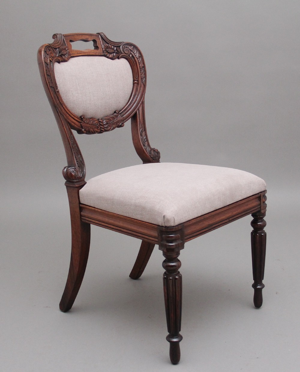 A set of six carved dark rosewood dining chairs with neutral fabric upholstered seats and padded backs. View II
